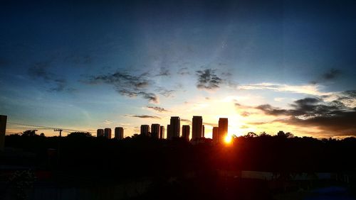 Silhouette buildings against sky during sunset