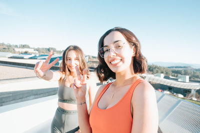 Portrait of female friends gesturing on terrace