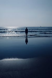 Man standing on beach against clear sky