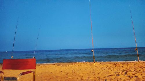 Scenic view of beach against clear blue sky