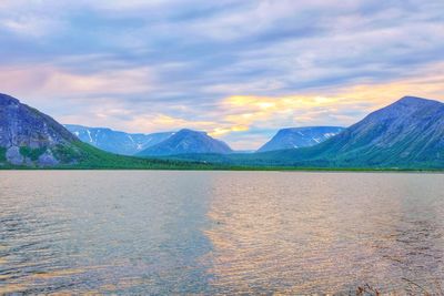 Scenic view of lake and mountains against sky during sunset