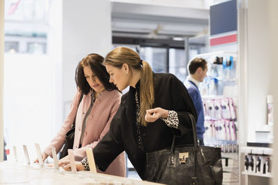 Female customers are using smart phones in showroom
