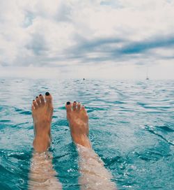 Low section of woman relaxing in sea