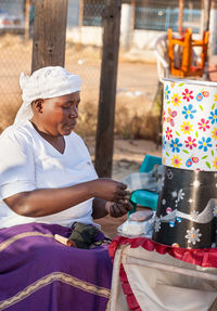 Vendor sitting by market stall