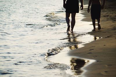 Low section of people standing on beach