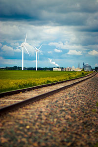 Windmills on wind turbines against sky