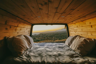 Sunset view of ocean over cliffs from bed of sprinter van in mexico.