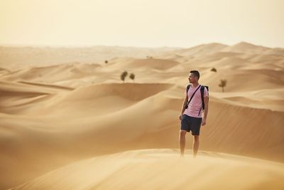 Full length of man on sand dune in desert