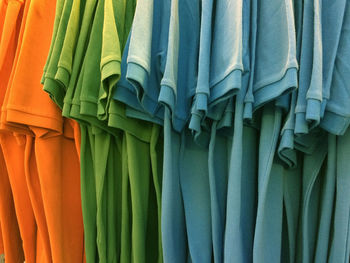 Close-up of multi colored clothes hanging on fabric for sale