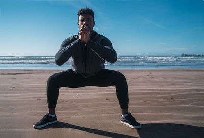 Young man exercising on beach