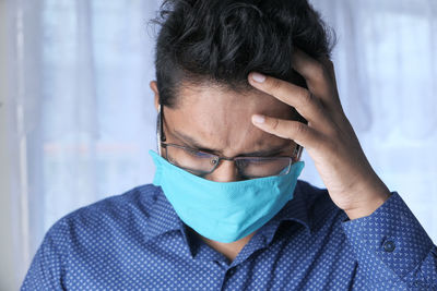 Close-up portrait of a man covering face