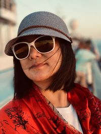 Portrait of smiling woman wearing sunglasses and hat outdoors