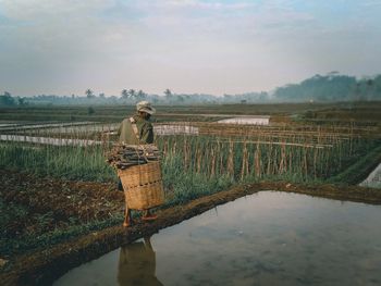 Rear view of man standing on land against sky