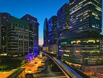 Illuminated buildings in city against sky at night