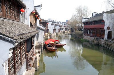 Boats in canal amidst buildings in city