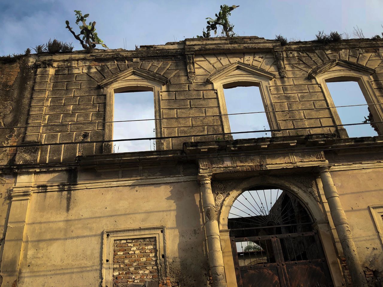 LOW ANGLE VIEW OF DAMAGED BUILDING AGAINST SKY