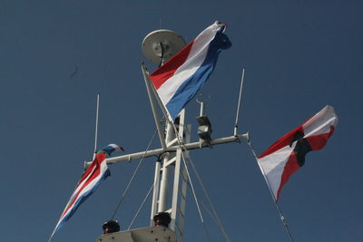 Low angle view of flags against clear sky