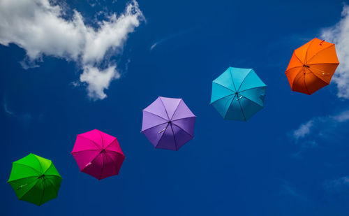 Low angle view of umbrellas against sky