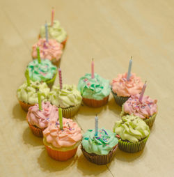 High angle view of candles in cupcakes on table