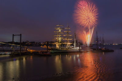 Firework display over river at night