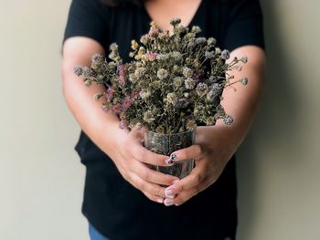 Midsection of woman holding flower bouquet