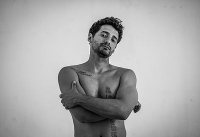 Portrait of young man standing against wall