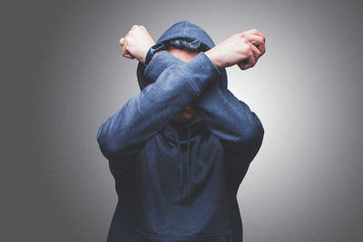 Midsection of man holding hands against white background