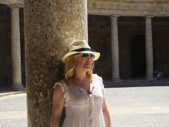 Portrait of young woman wearing sunglasses standing outdoors