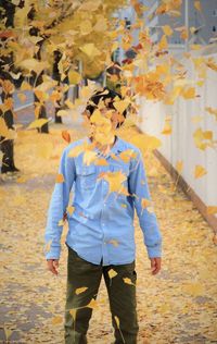 Full length of man standing on autumn leaves