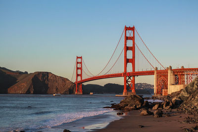 Golden gate bridge over sea against clear blue sky