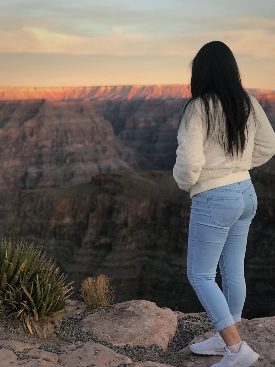 real people, rock - object, rear view, nature, rock formation, one person, beauty in nature, sunset, leisure activity, scenics, landscape, tranquility, full length, tranquil scene, physical geography, lifestyles, standing, outdoors, mountain, travel destinations, women, arid climate, day, sky, people