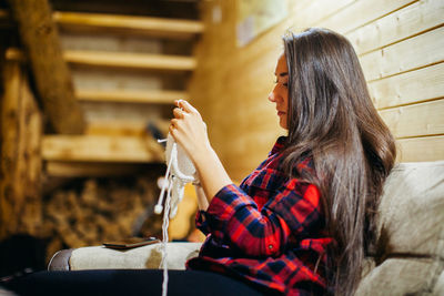 Side view of young woman sitting outdoors