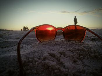 Close-up of red sunglasses against sky