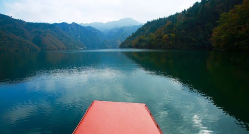 Scenic view of lake by mountains against sky