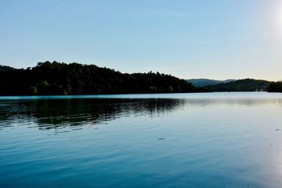 Scenic view of lake against clear blue sky