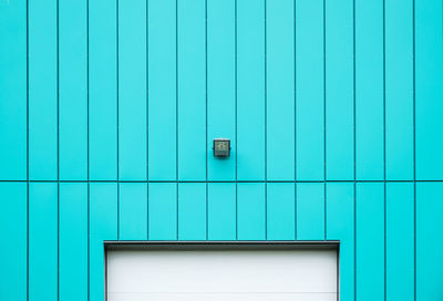 Electric light mounted on turquoise wall