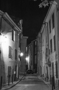Empty street amidst buildings at night
