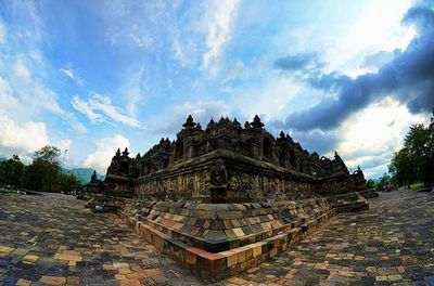 Ancient temple against cloudy sky