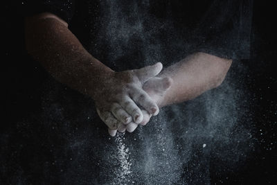 Close-up of hands against black background