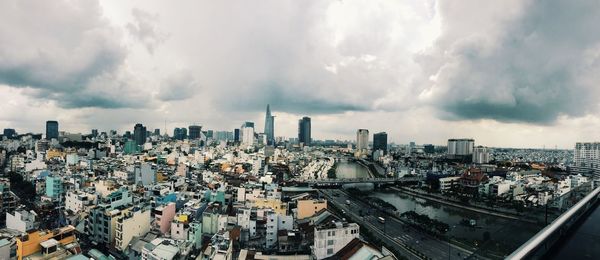 Modern cityscape against cloudy sky