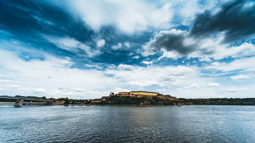 Scenic view of river against cloudy sky