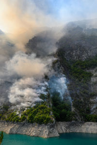 Smoke emitting from volcanic mountain against sky