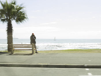 Man standing on beach against sky