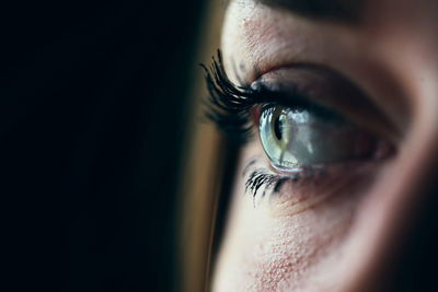 Close-up of woman eye over black background