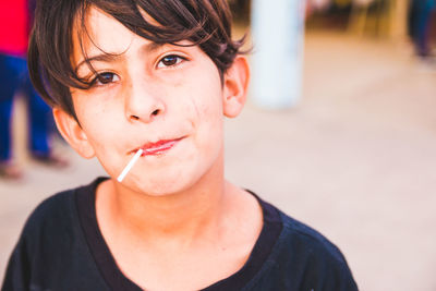 Close-up portrait of boy eating lollipop