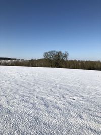 Scenic view of snow field against clear blue sky