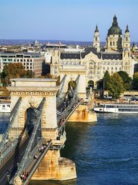 Bridge over river against buildings in city