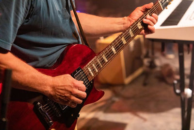 Midsection of man playing guitar