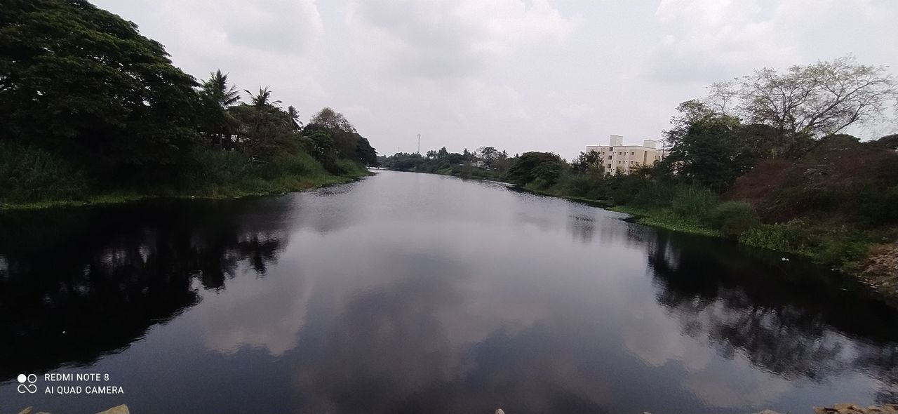 LAKE AMIDST TREES AGAINST SKY