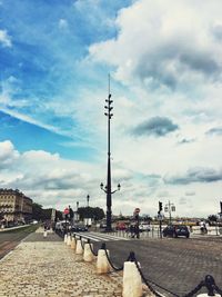People at town square against cloudy sky